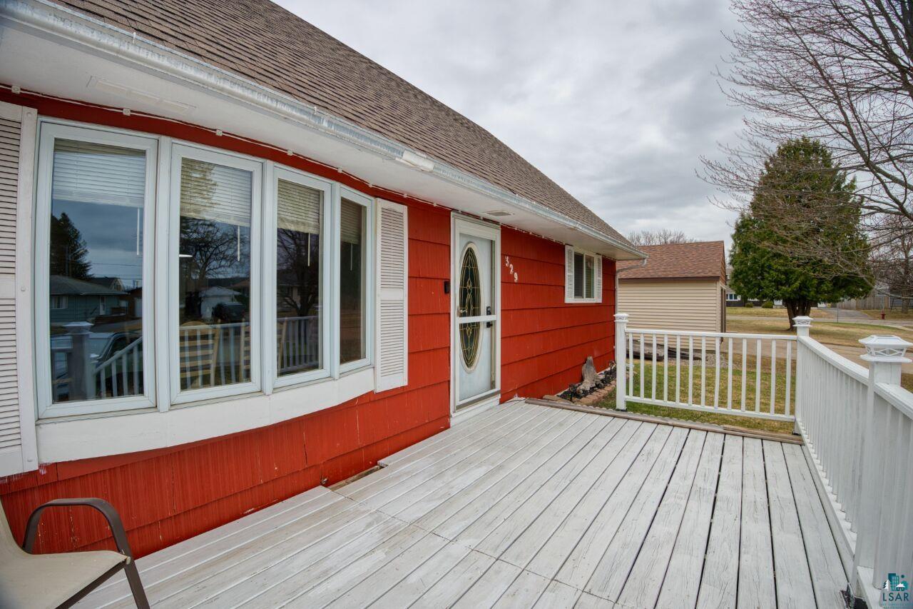 329 Wyandotte Road Hoyt Lakes, MN 55750 - Photo 45 of 52 Exterior featuring red siding, a white front door with an oval glass insert, and a white-painted wooden deck