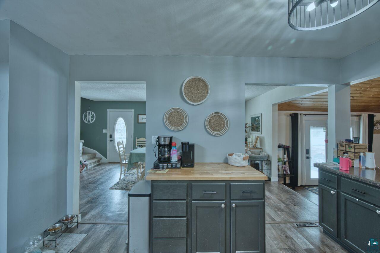 329 Wyandotte Road Hoyt Lakes, MN 55750 - Photo 5 of 52 Kitchen featuring a central island with wood-finish countertop, dark cabinetry, and wood-finish flooring