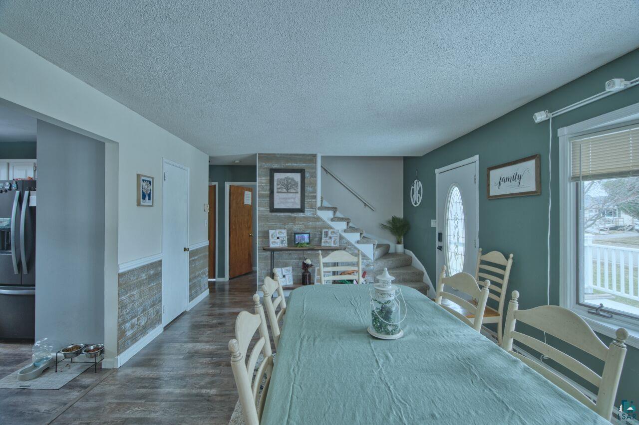 329 Wyandotte Road Hoyt Lakes, MN 55750 - Photo 9 of 52 Spacious dining area featuring wood-finish flooring and an accent wall with a durable white railing
