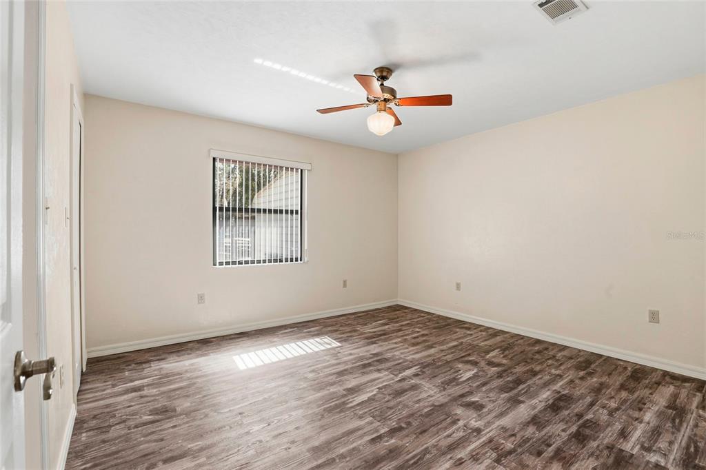 534 Southwest Thorne Lane Fort White, FL 32038 - Photo 29 of 51 an empty room with wooden floor fan and windows