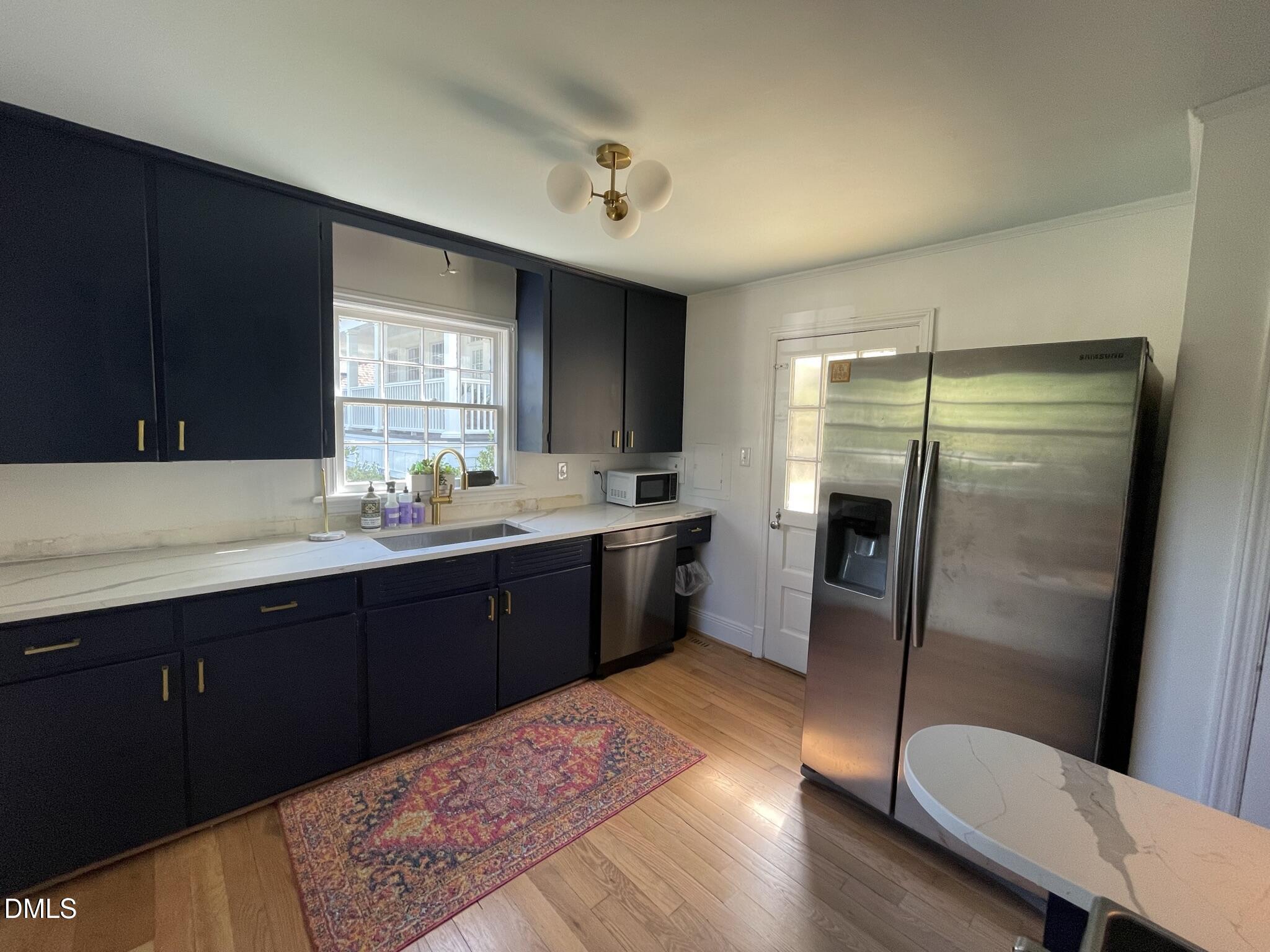 1009 Canterbury Road Raleigh, NC 27607 - Photo 2 of 31 a kitchen with a sink a refrigerator a window and cabinets