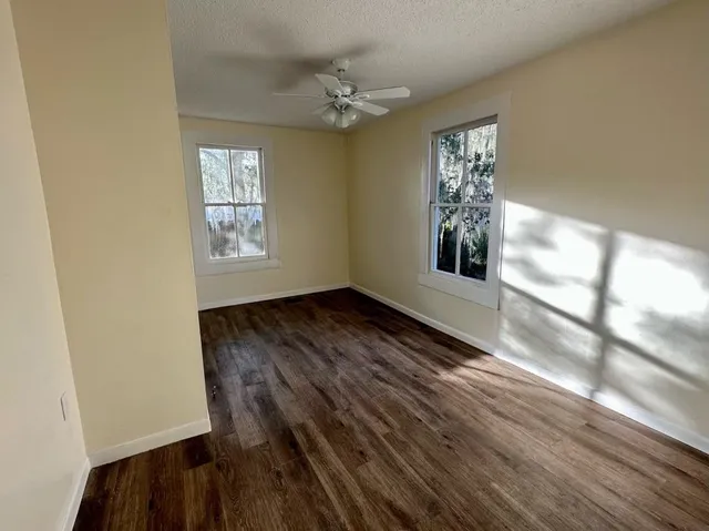 a view of a hallway with wooden floor and a window