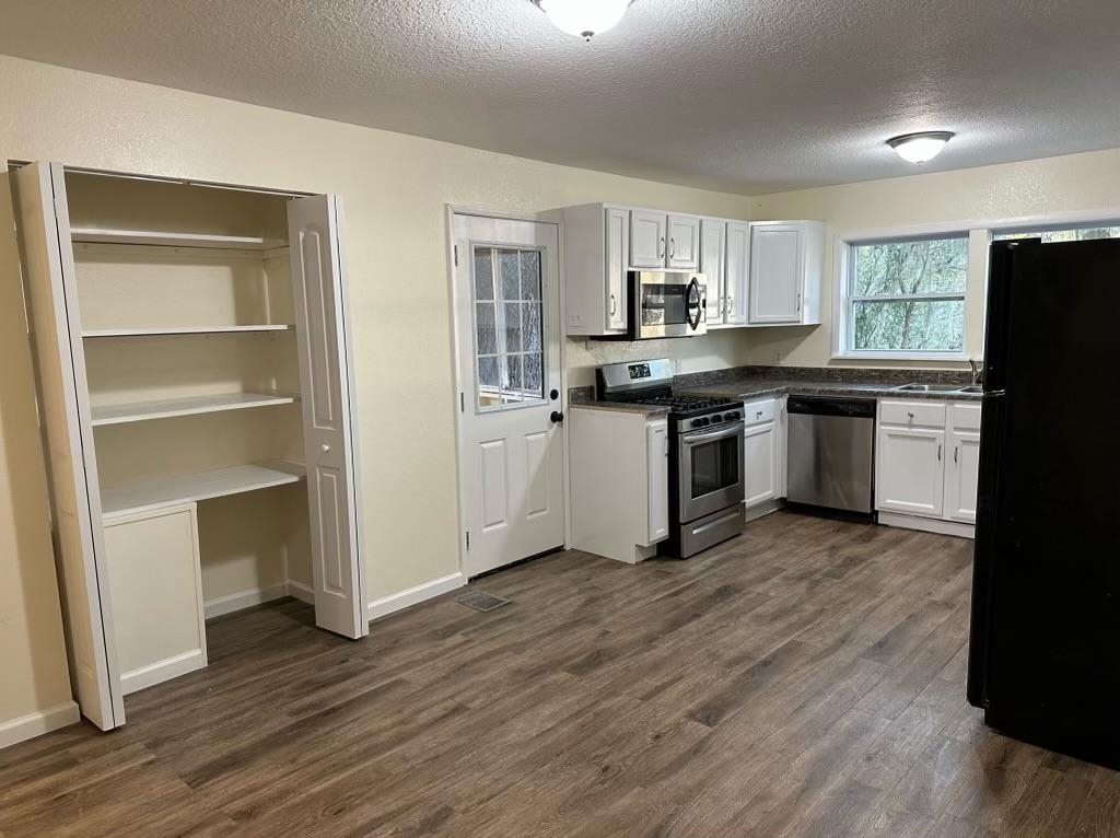 1900 Twigg Street Palatka, FL 32177 - Photo 8 of 10 a kitchen with a refrigerator cabinets and wooden floor