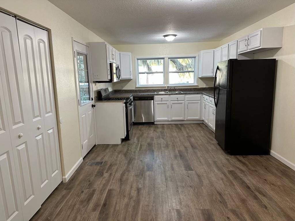 1900 Twigg Street Palatka, FL 32177 - Photo 9 of 10 a kitchen with a refrigerator wooden floor and window