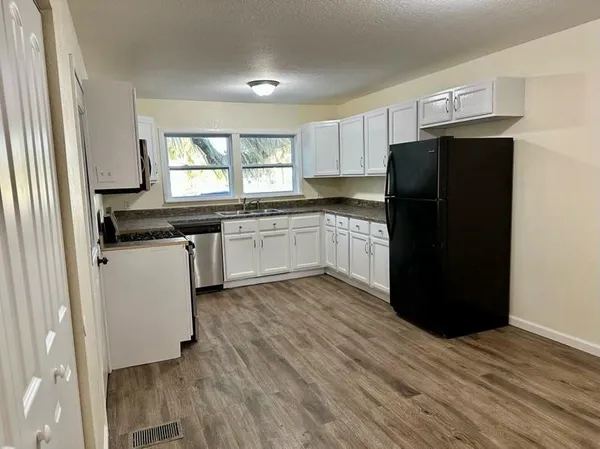 a kitchen with a refrigerator and white cabinets