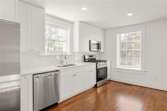 a kitchen with a sink wooden floor and window