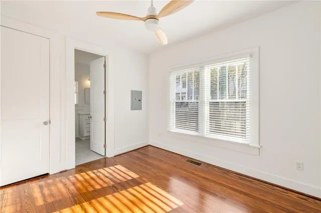 a view of an empty room with a window and wooden floor