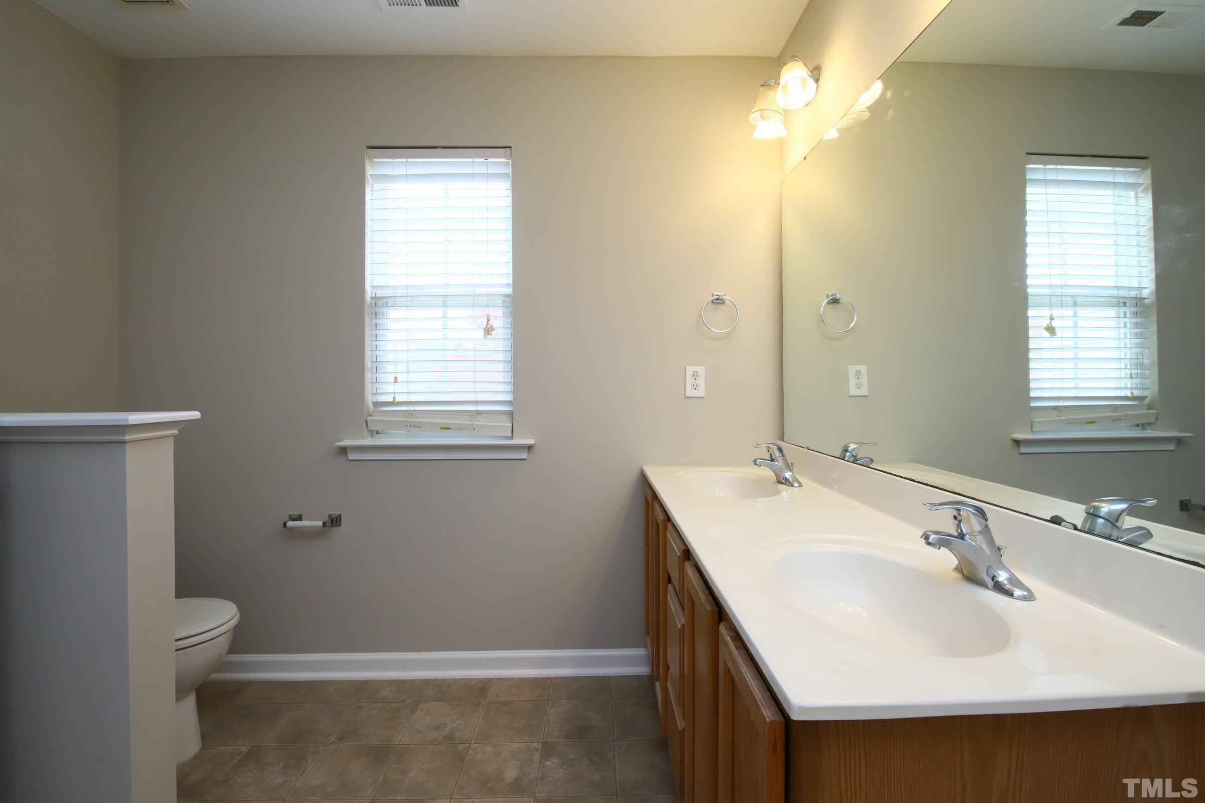 8205 Martello Lane Raleigh, NC 27613 - Photo 17 of 28 a bathroom with a sink toilet and vanity