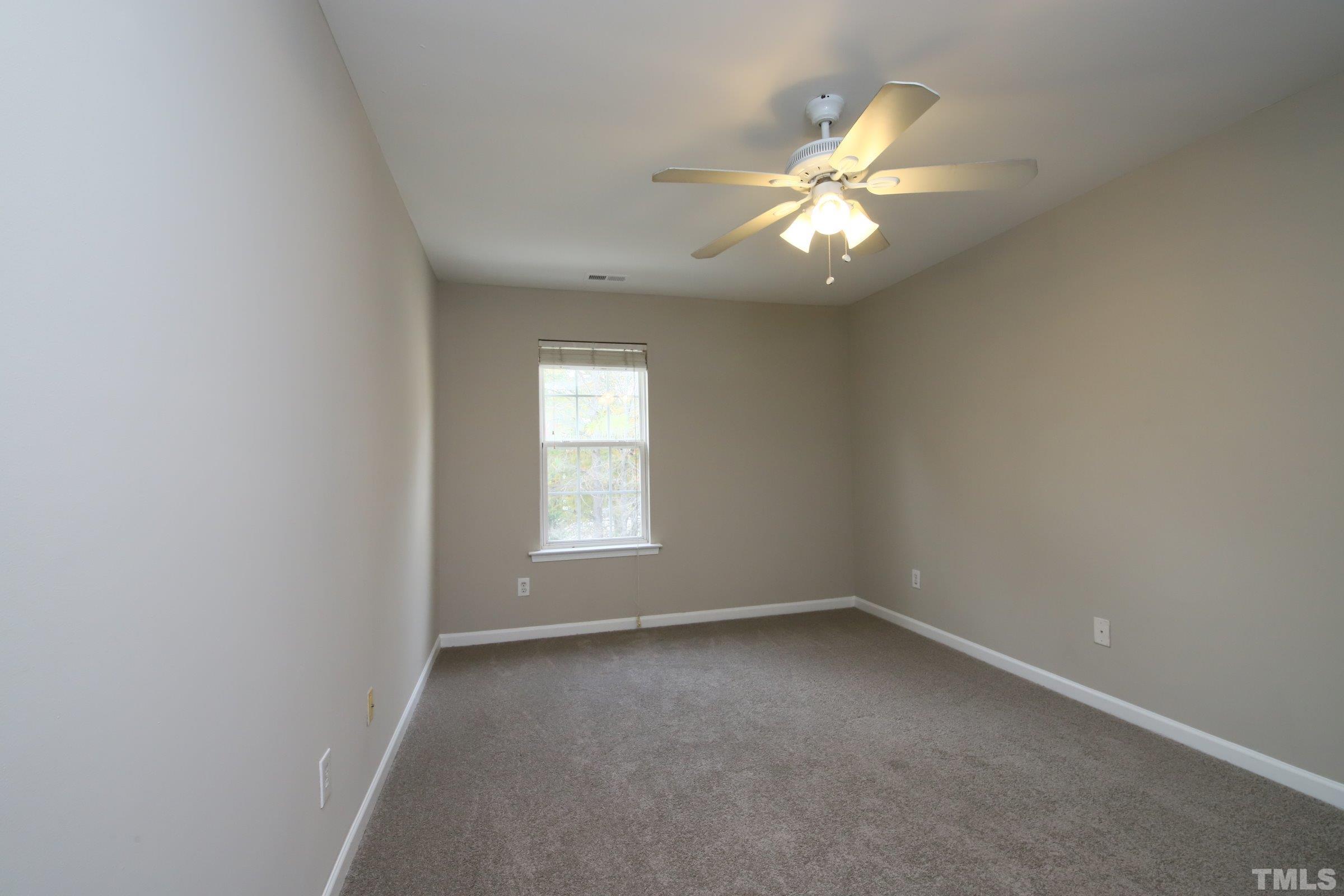 8205 Martello Lane Raleigh, NC 27613 - Photo 21 of 28 an empty room with a window and a fan