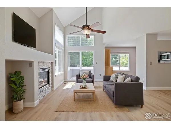 a living room with furniture a flat screen tv and a fireplace
