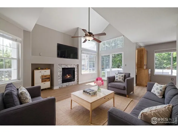a living room with furniture a flat screen tv and a fireplace