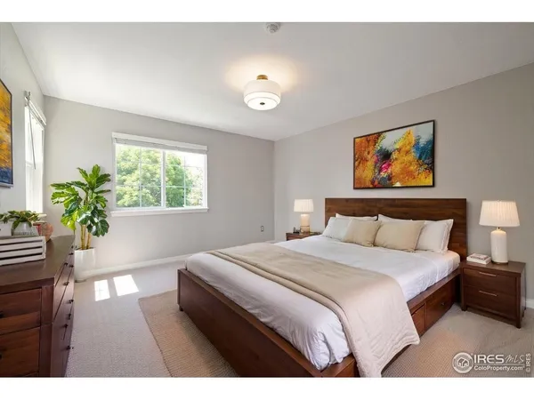 a spacious bedroom with a large bed and a potted plant
