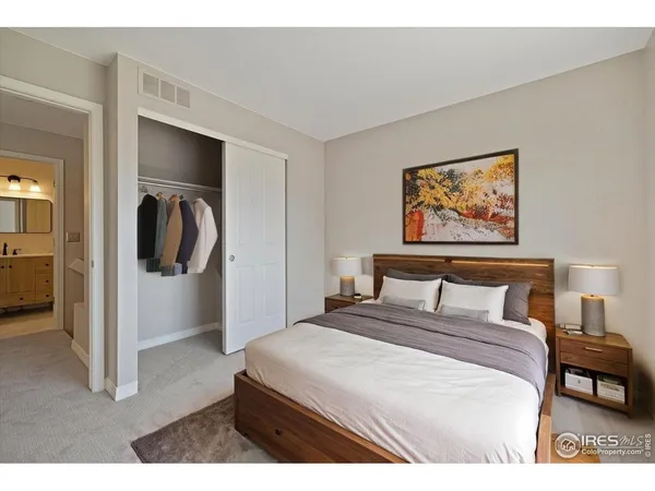 a bedroom with a bed and a painting on the wall