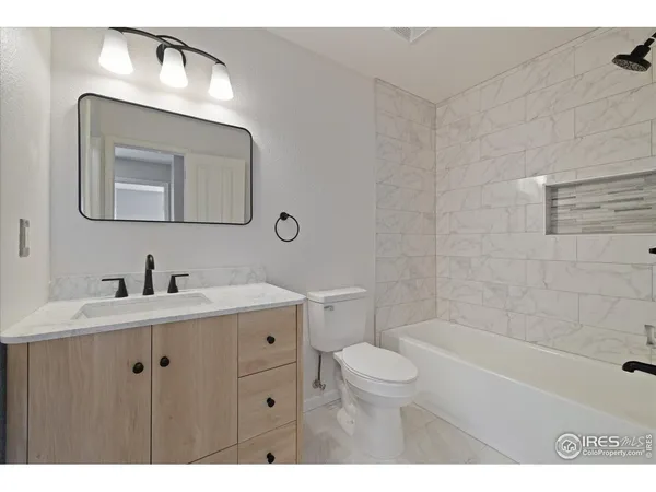 a bathroom with a toilet a sink a mirror and bathtub