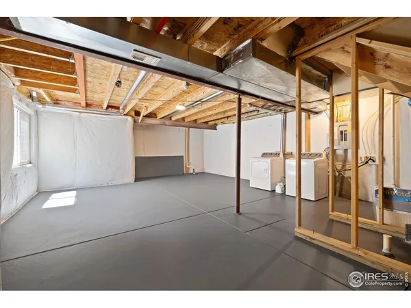 a view of an empty room with wooden floor and windows