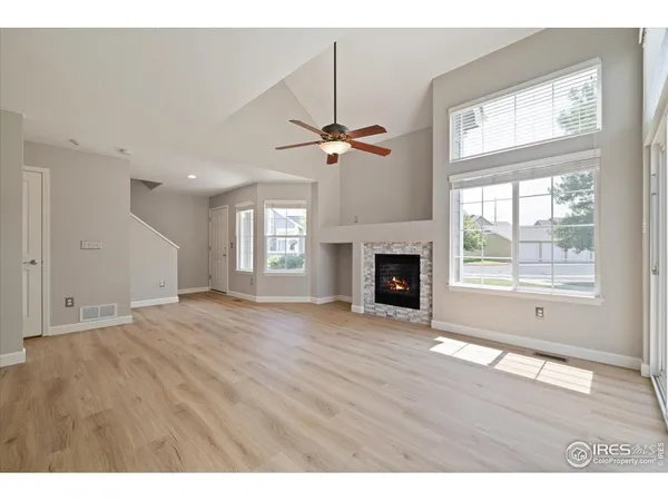 a view of an empty room with a window and a kitchen