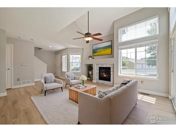 a living room with furniture a fireplace and a chandelier