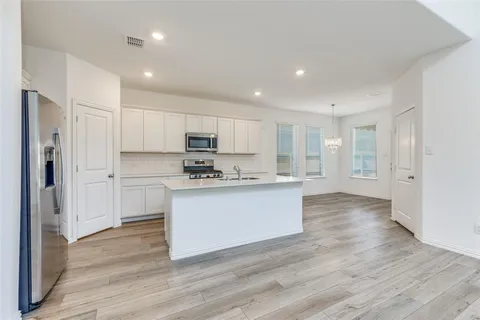 a kitchen with wooden floors and white appliances