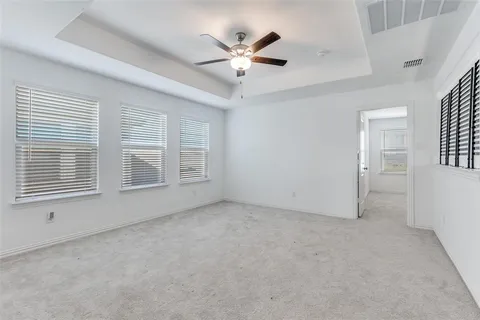 an empty room with ceiling fan and window