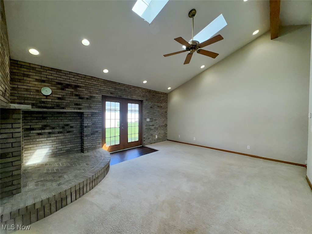 6224 Reynolds Road Mentor, OH 44060 - Photo 9 of 29 Unfurnished living room with french doors, brick wall, carpet floors, a skylight, and recessed lighting
