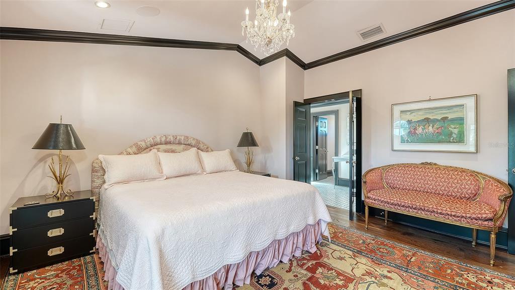 513 Villa Rosa Way Anna Maria, FL 34216 - Photo 15 of 57 a bedroom with a bed and a chandelier