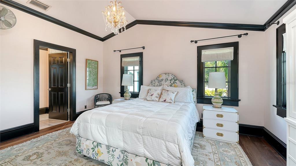 513 Villa Rosa Way Anna Maria, FL 34216 - Photo 19 of 57 a bedroom with a bed and a chandelier