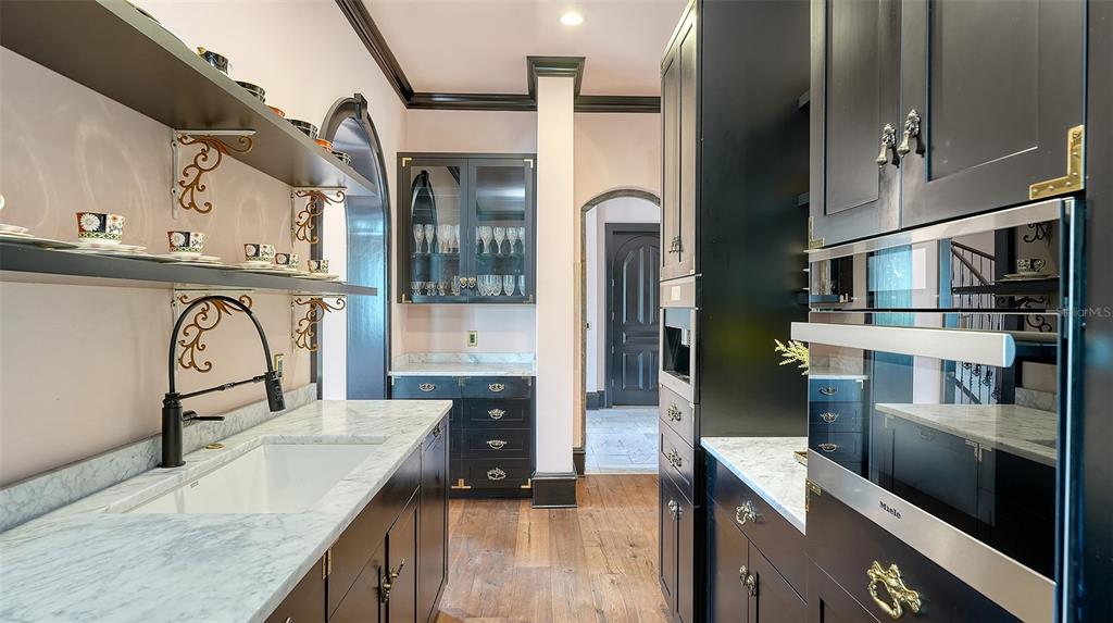 513 Villa Rosa Way Anna Maria, FL 34216 - Photo 48 of 57 a kitchen with stainless steel appliances granite countertop a refrigerator a stove and a sink with wooden floor
