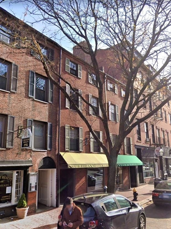 83 Charles Street, Unit 1 Boston, MA 02114 - Photo 11 of 11 a front view of a building with street view and trees