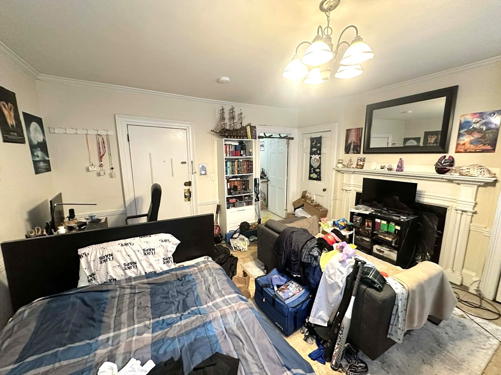 83 Charles Street, Unit 1 Boston, MA 02114 - Photo 2 of 11 a living room with furniture a flat screen tv and a fireplace