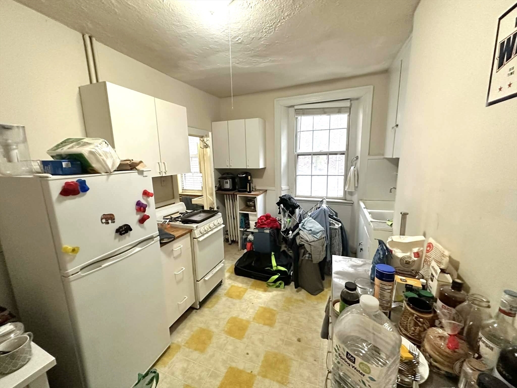 83 Charles Street, Unit 1 Boston, MA 02114 - Photo 6 of 11 a kitchen with a sink appliances cabinets and a window