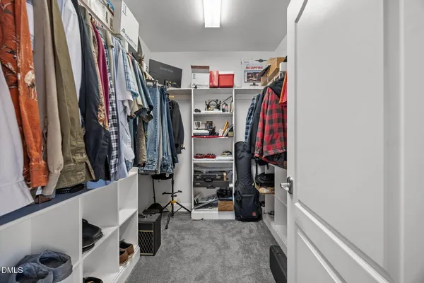 a view of walk in closet with clothes and shoes