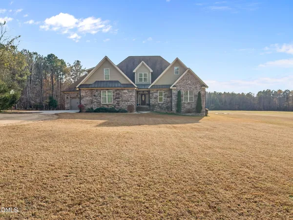 a front view of a house with a yard and fountain in middle of the house