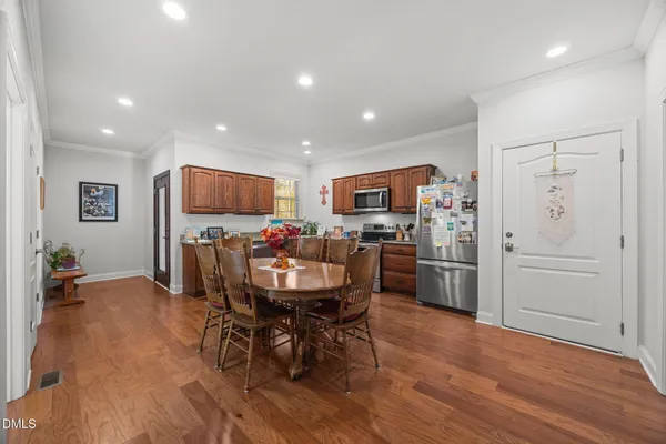 a view of a dining room with furniture and a refrigerator