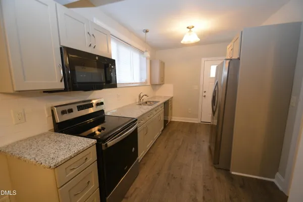 a kitchen with a sink stove and microwave