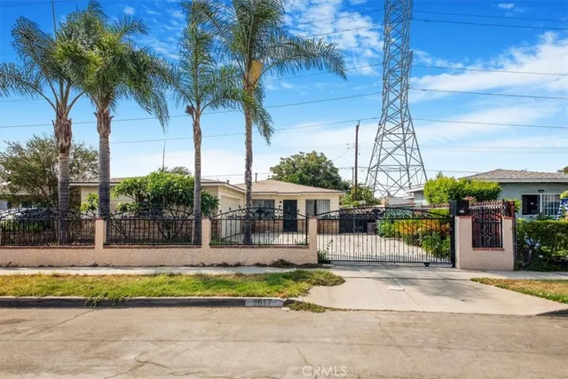 a front view of a house with a garden and tree