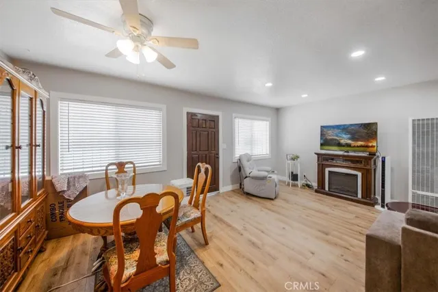 a view of a dining room with furniture a fireplace and wooden floor