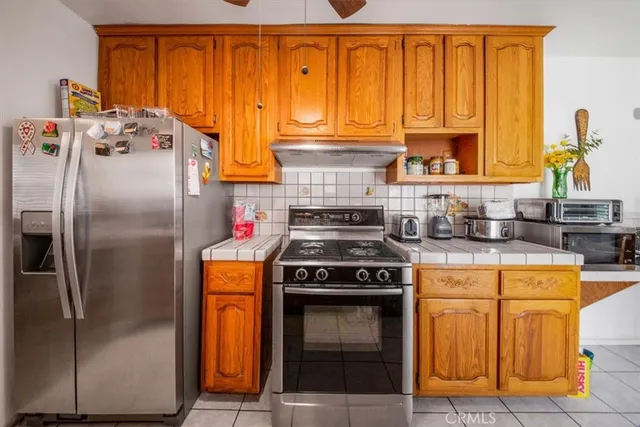 a kitchen with stainless steel appliances granite countertop a stove a refrigerator and a sink