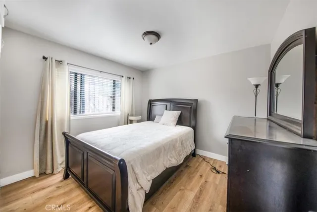 a bedroom with a bed and dresser with mirror