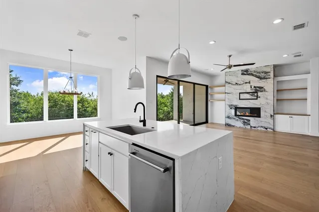 a kitchen with kitchen island granite countertop a sink appliances and a counter top space