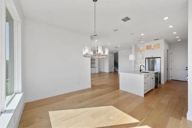 a view of a kitchen with kitchen island white cabinets and wooden floor