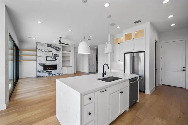 a kitchen with stainless steel appliances granite countertop a sink and a refrigerator
