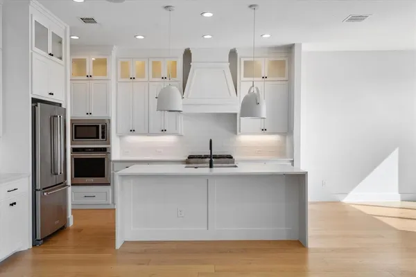 a kitchen with kitchen island a counter top space cabinets and stainless steel appliances