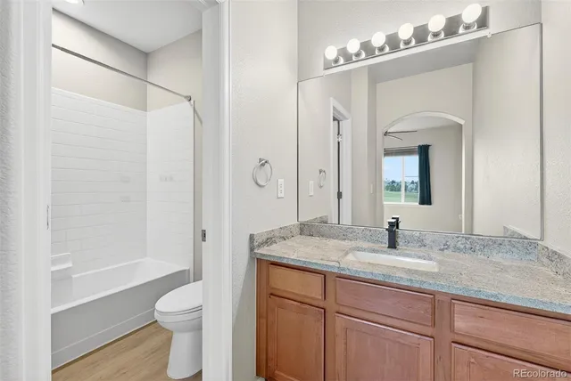 a bathroom with a granite countertop sink toilet and shower