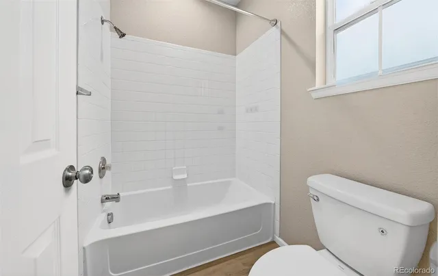 a white toilet sitting next to a bath tub