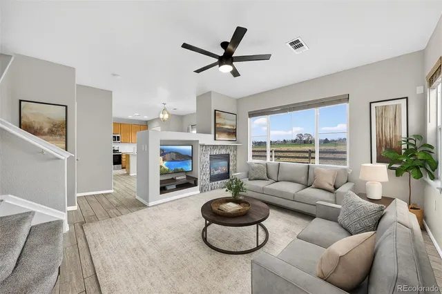 a living room with furniture a fireplace and a large window
