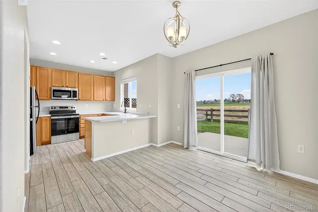 a kitchen with wooden floors and white cabinets