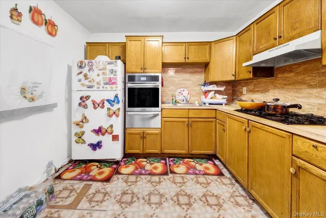 a kitchen with stainless steel appliances a stove a sink and a refrigerator