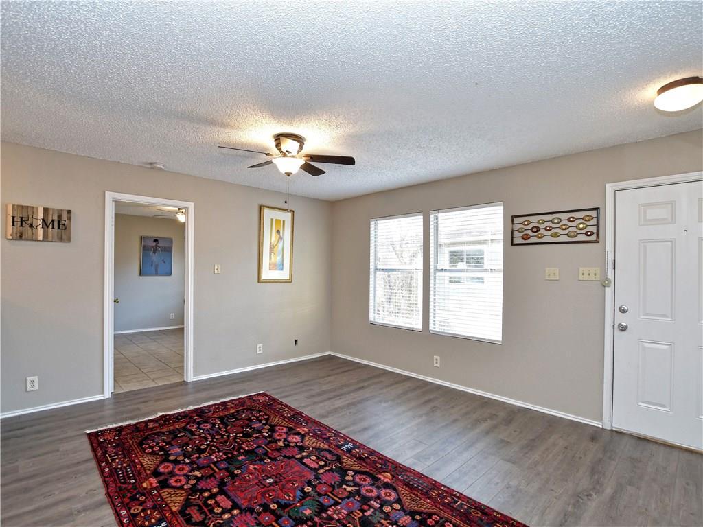 5401 Spring Meadow Road, Unit B Austin, TX 78744 - Photo 2 of 21 A well-lit living area features attractive flooring and a ceiling fan for comfort.