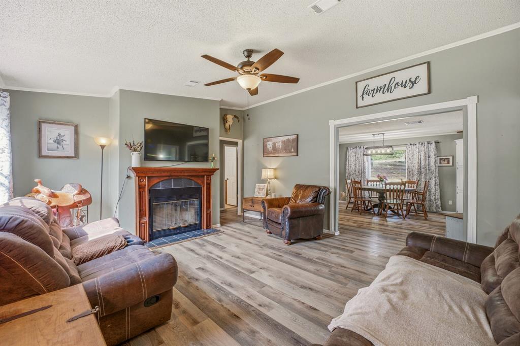 151 High Point Road Weatherford, TX 76088 - Photo 6 of 40 a living room with furniture a fireplace and a flat screen tv