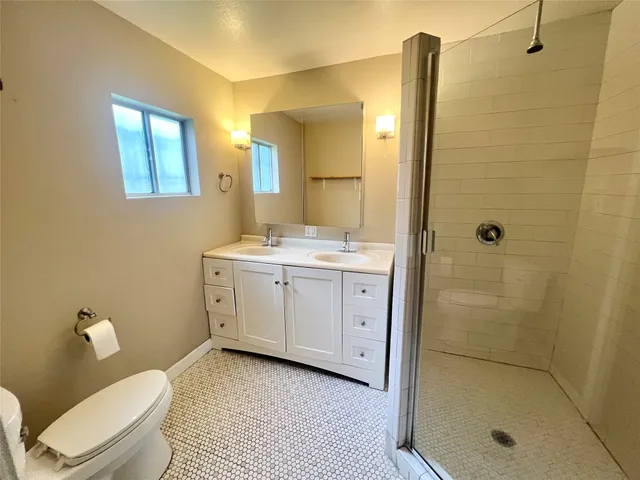 a bathroom with a granite countertop sink toilet and shower